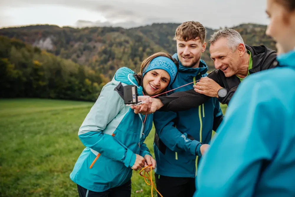 Lachende Gruppe beim Üben mit dem Kompass